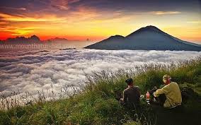 Sunrise view from Mount Batur with golden light over the volcanic crater and Lake Batur.