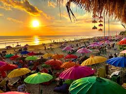 Golden hour at Seminyak Beach with waves rolling in and people enjoying the sunset.