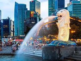 The iconic Merlion statue spouting water into Marina Bay with the Singapore skyline in the background.
