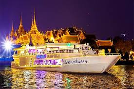 Long-tail boat cruising the Chao Phraya River at sunset.