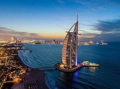 Burj Al Arab luxury hotel on Dubai coastline at sunset