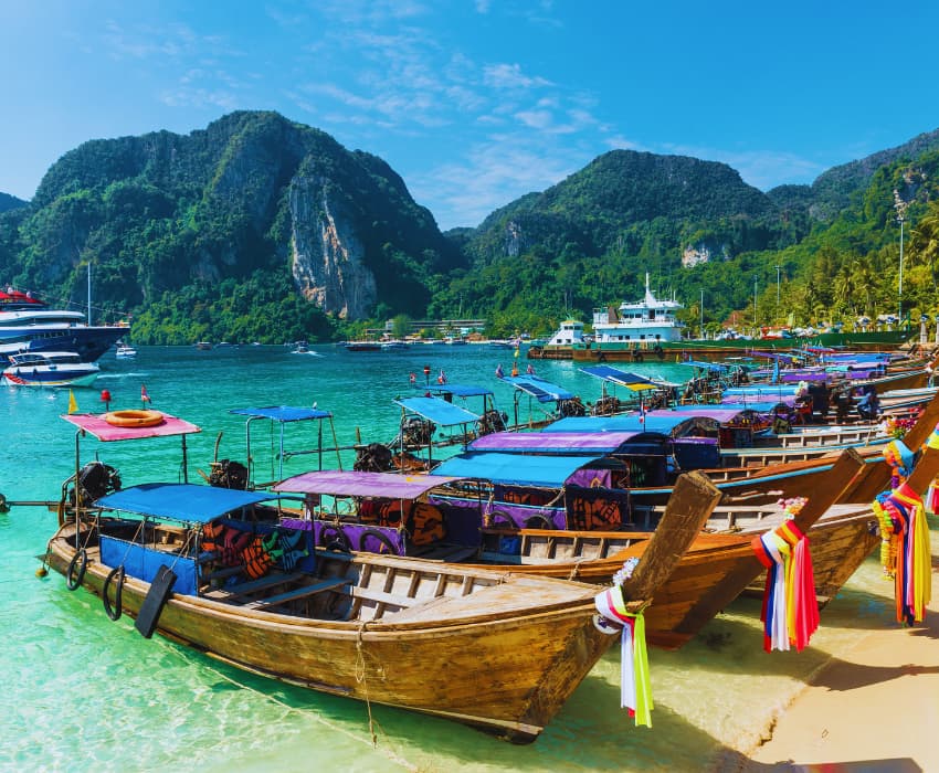 Stunning aerial view of Phi Phi Islands with turquoise water, limestone cliffs, and boats anchored near the shore