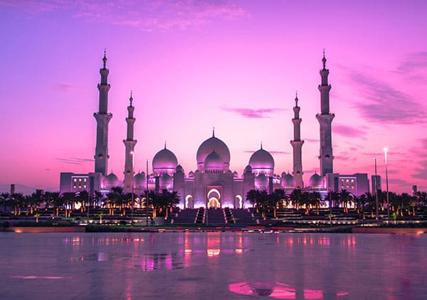 Sheikh Zayed Grand Mosque illuminated at sunset in Abu Dhabi